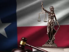 Texas US state flag with statue of lady justice^ constitution and judge hammer on black drapery.