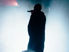 Silhouette of a singer/rapper with a towel. Bright background.