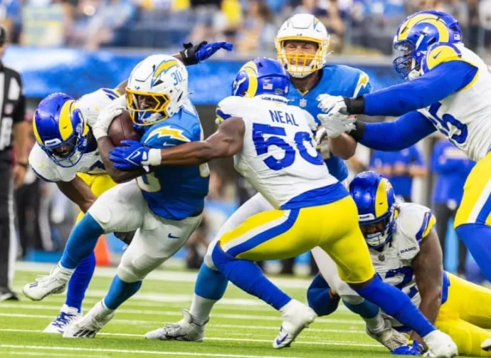 LA Chargers running back Kimani Vidal #30 runs the ball fighting off pressure from the LA Rams in an NFL football game at SoFi Stadium^ Aug. 17^ 2024^ in Inglewood^ CA.