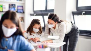 teacher-and-children-with-face-mask-back-at-school-after-covid-19-quarantine-and-lockdown