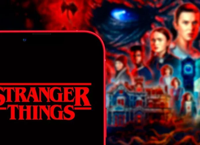 Computer keyboard with the Iphone 11 pro with the Stranger Things logo.