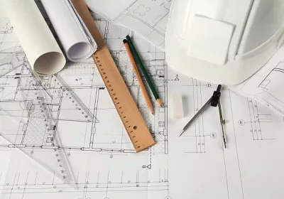 rulers-pencils-compass-hardhat-and-an-eraser-on-architectural-blueprints