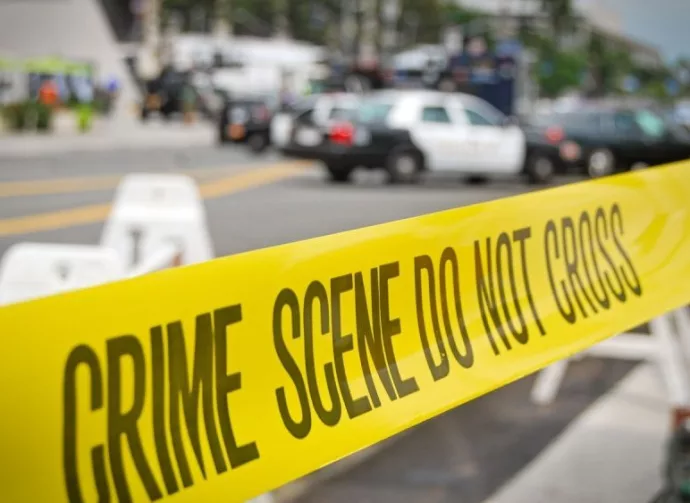 crime or accident scene sign do not pass the line with police cars in the background