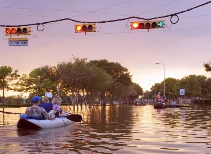 Working traffic lights over flooded Houston streets and boats with people at sunset. Texas^ USA