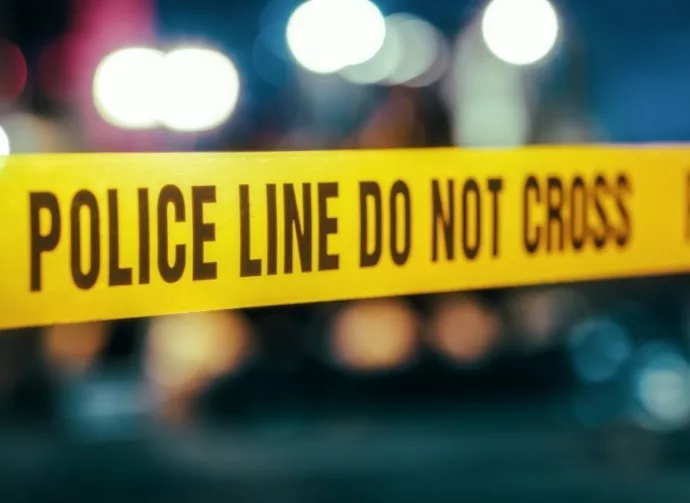 Yellow Tape Showing Text "Police Line Do Not Cross" Restricting a Crime Scene Area At Night. Close Up Aesthetic Shot with Bokeh Effect and Flickering Lights.