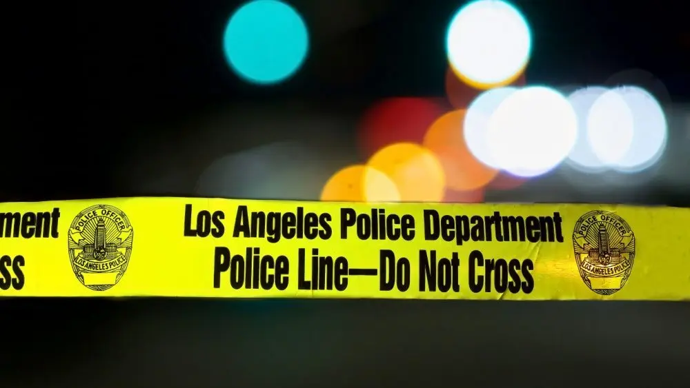 Police barricade tape with the writing 'LOS ANGELES POLICE DEPARTMENT POLICE LINE - DO NOT CROSS' illuminated night exterior with deliberately blurred background Los Angeles - January 2^ 2021
