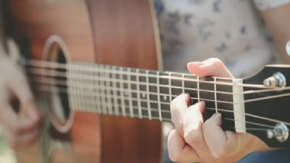 close of of hand playing guitar