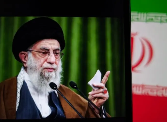 This image captures Iranian Supreme Leader Ali Khamenei giving a speech^ with the Iranian flag prominently displayed.