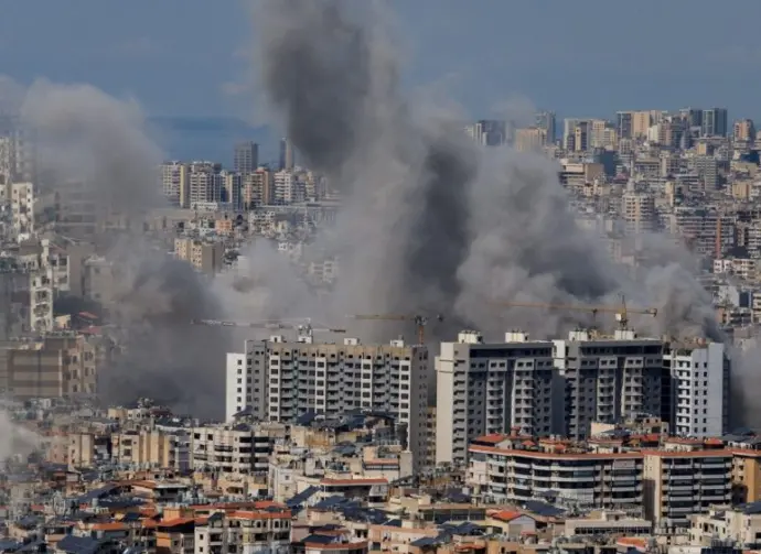 Multiple large plumes of thick grey smoke billow from residential apartment complexes following an explosion or missile strike in a crowded urban skyline. Jan 3 2021 in Iran