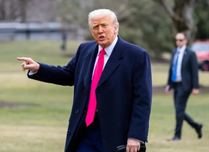 President Donald Trump points while on the South Lawn as he walks into the White House. WASHINGTON – February 22^ 2025