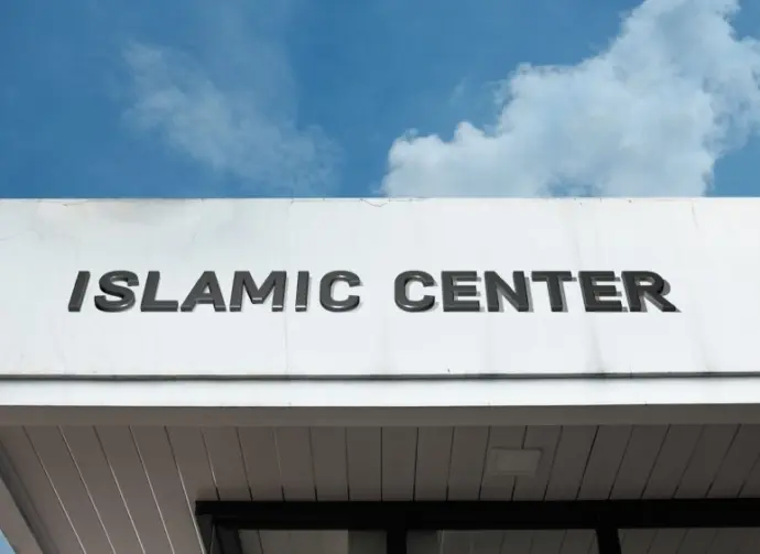 Islamic Center sign on a community building under blue sky^ symbolizing worship^ cultural education^ Muslim community services^ faith^ and spiritual guidance