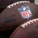 NLF footballs are displayed before an NFL football game between the Los Angeles Rams and the Seattle Seahawks at SoFi Stadium Sunday Nov. 16^ 2025^ in Inglewood^ Calif.
