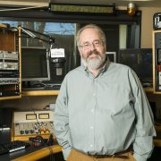Man stands inside radio broadcast studio