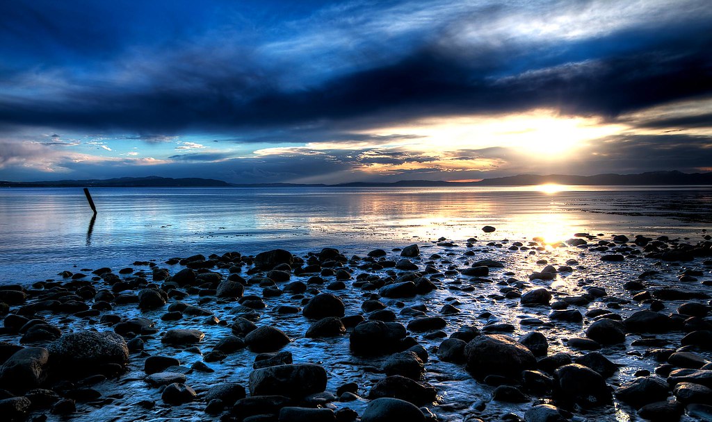 Photo of rocks along an ocean coastline at sunset