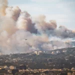 Wildfire in Pacific Palisades^ Los Angeles^ January 8^ 2025^ towards Getty Center and Brentwood. Images showcase dense smoke clouds^ burning hillsides^ and urban areas at risk.