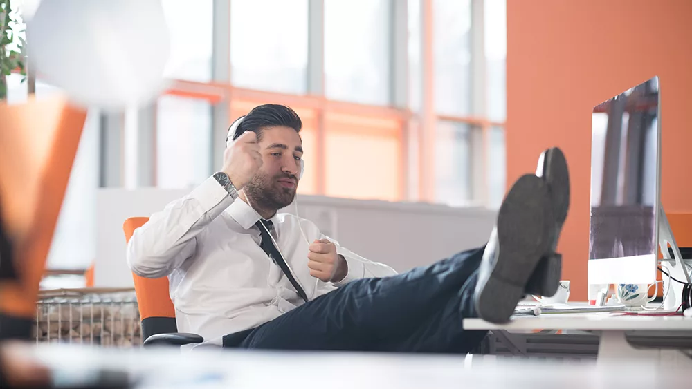 man at desk playing air drums