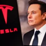 Elon Musk^ CEO of Tesla^ in a formal suit with the Tesla logo in the background. The image depicts electric vehicles^ innovations^ and tech leadership.