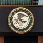 Seal of Justice Department seen during press conference at US Attorney Office library