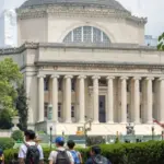 Students at the Columbia University campus on the Upper West Side of Manhattan. Steps of the Low Memorial Library in the background. New York^ NY^ USA - July 8^ 2022: