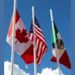 Flags of United States^ Mexico^ Canada flying together^ concept of new NAFTA agreement now known as USMCA in the U.S.^ CUSMA in Canada or T-MEC in Mexico.