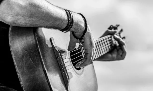 Acoustic guitars playing. Music concept. Black and white. Male musician playing guitar^ music instrument. Man's hands playing acoustic guitar^ close up.