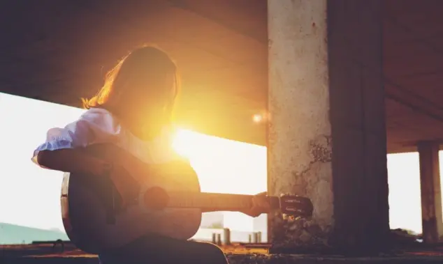 Candid silhouette woman chill play acoustic guitar musician Artists female sad mood activity music at balcony flare lighting sunset background