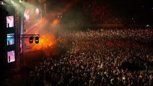 Large Concert Crowd and Stage Lighting in a Stadium at Night