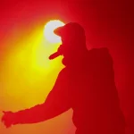 Silhouette of rap singer with microphone in hand. Rapper performing on concert.