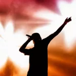 rapper on stage performing ;silhouette