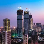 istockphoto-1325342016: A twilight view of the skyline of the eastern seaboard of Mumbai Mumbai under construction.
