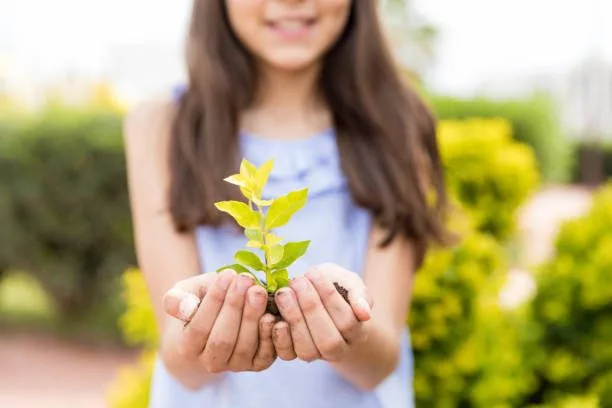 hispanic-girl-protecting-small-plant-on-earth-day-in-garden-2