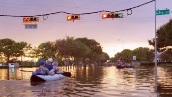 Working traffic lights over flooded Houston streets and boats with people at sunset. Texas^ USA