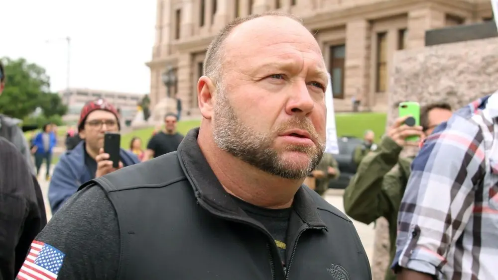 Alex Jones^ flanked by bodyguards^ leaves a rally protesting Covid-19 stay at home orders at the Capitol that was heavily promoted by his Infowars website. Austin^ Tx/USA - Apr. 18^ 2020