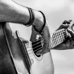 Acoustic guitars playing. Music concept. Black and white. Male musician playing guitar^ music instrument. Man's hands playing acoustic guitar^ close up.
