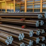 Rows of Steel Round Bar storage and stacking in the warehouse for industrial construction.