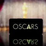 A smartphone displaying the Oscars logo against a blurred awards ceremony background. January 13^ 2025