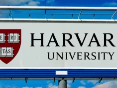 billboard displaying logo of Harvard University^ a private Ivy League research university in Cambridge^ Massachusettsl