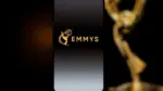 Emmys logo displayed on a smartphone screen with a blurred gold award statuette in the background^ television industry awards and digital streaming concept. Kaunas^ Lithuania - 2026 March 24