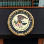 Seal of Justice Department seen during press conference at US Attorney Office library