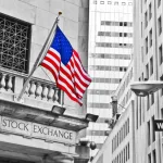 Side entrance of New York Stock Exchange and a street sign of Wall Street shown on October 11^ 2013 in New York City.