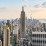 A stunning view of New York City^ showcasing iconic landmarks with the Empire State Building as its centerpiece