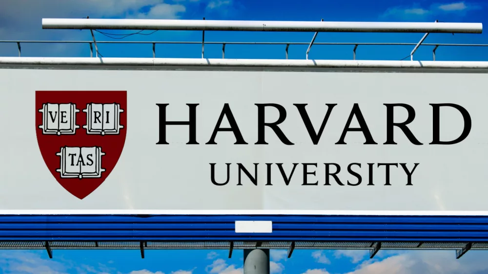 billboard displaying logo of Harvard University, a private Ivy League research university in Cambridge, Massachusettsl