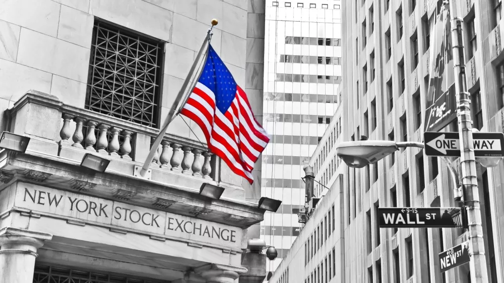 Side entrance of New York Stock Exchange and a street sign of Wall Street shown on October 11, 2013 in New York City.