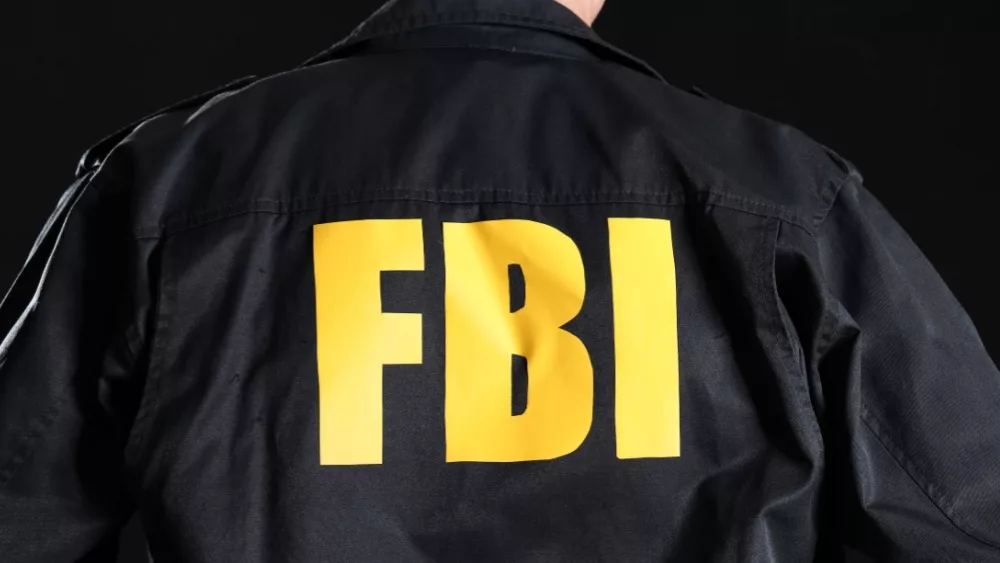 Mature FBI agent on black background, back view