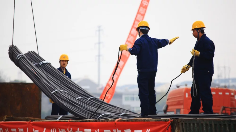 China's eastern city of Jiujiang, workers in the steel building materials market hoisting steel. China's steel demand slump triggered the global steel industry downturn.