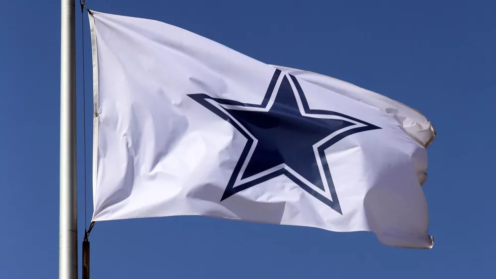 Dallas Cowboys flag flies in front of the AT&T Stadium located in Arlington, Texas