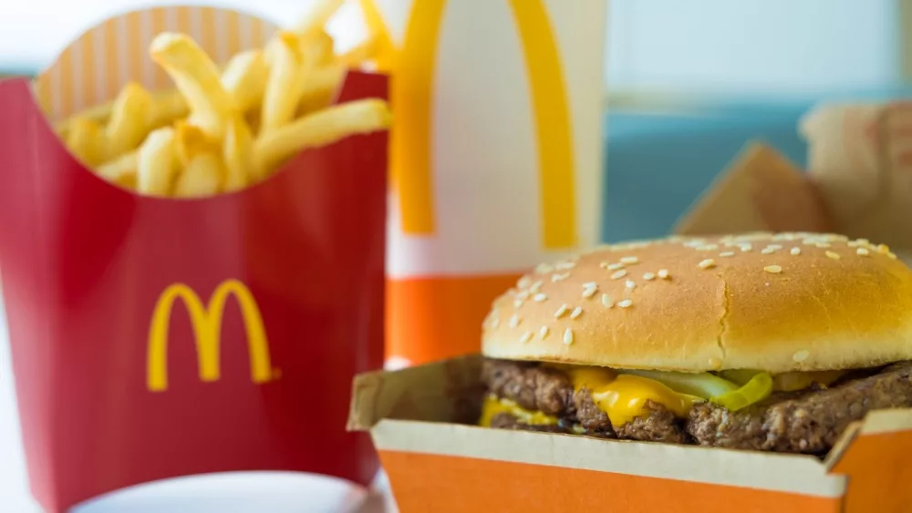 Selective focus on McDonald's Double Quarter Pounder burger with chesse, french fries potatoes and drink.