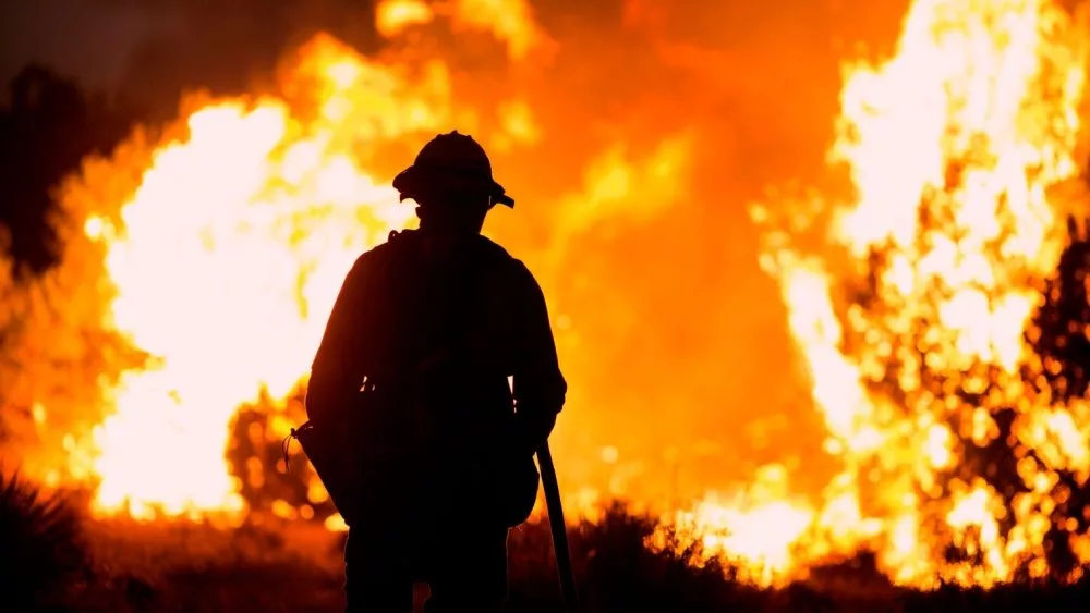 A firefighter watches as the Bobcat Fire burns in Juniper Hills, California, Saturday, Sept. 19, 2020.