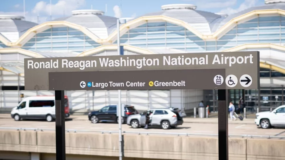 Sign for Washington National Airport with the airport terminal in the background. Washington D.C. USA- July 12th, 2021