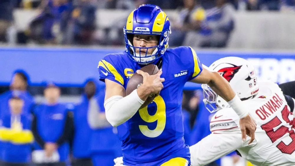 Los Angeles Rams Matthew Stafford #9 escapes a tackle-attempt by Arizona Cardinals Julian Okwara #58 during an NFL football game at SoFi Stadium, Dec. 28, 2024, in Inglewood, Calif.